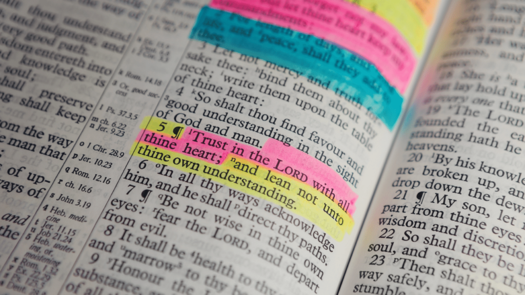 A page from the Bible is highlighted in pink, yellow, and blue on 5 Bible verses for anxiety.