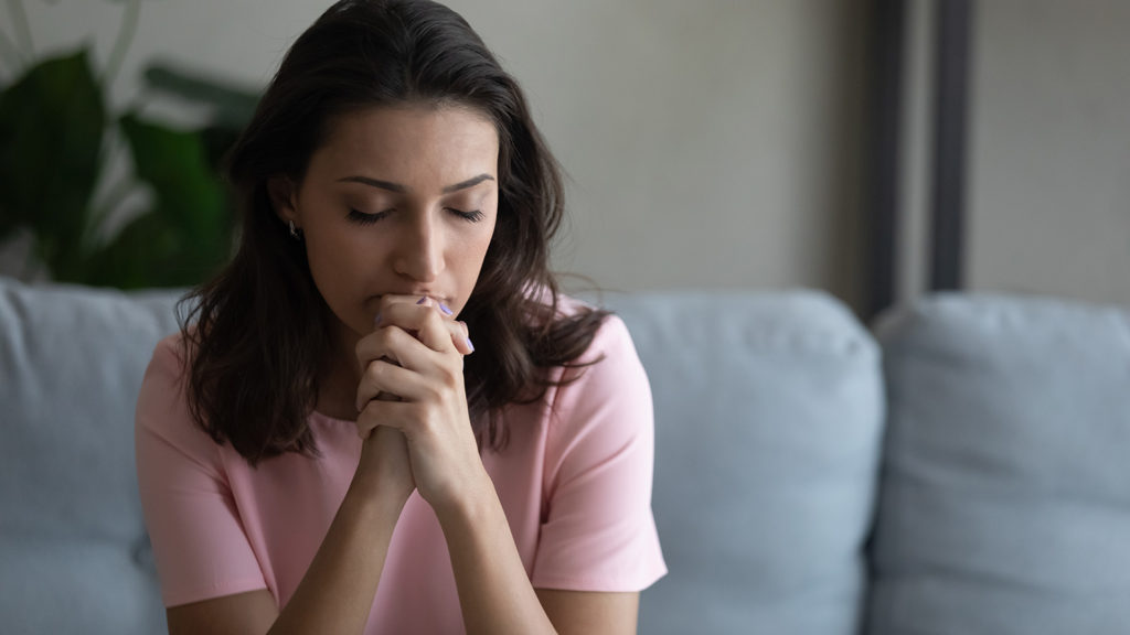 Royalty-Free Stock Photo: Woman saying prayers for healing anxiety and depression.