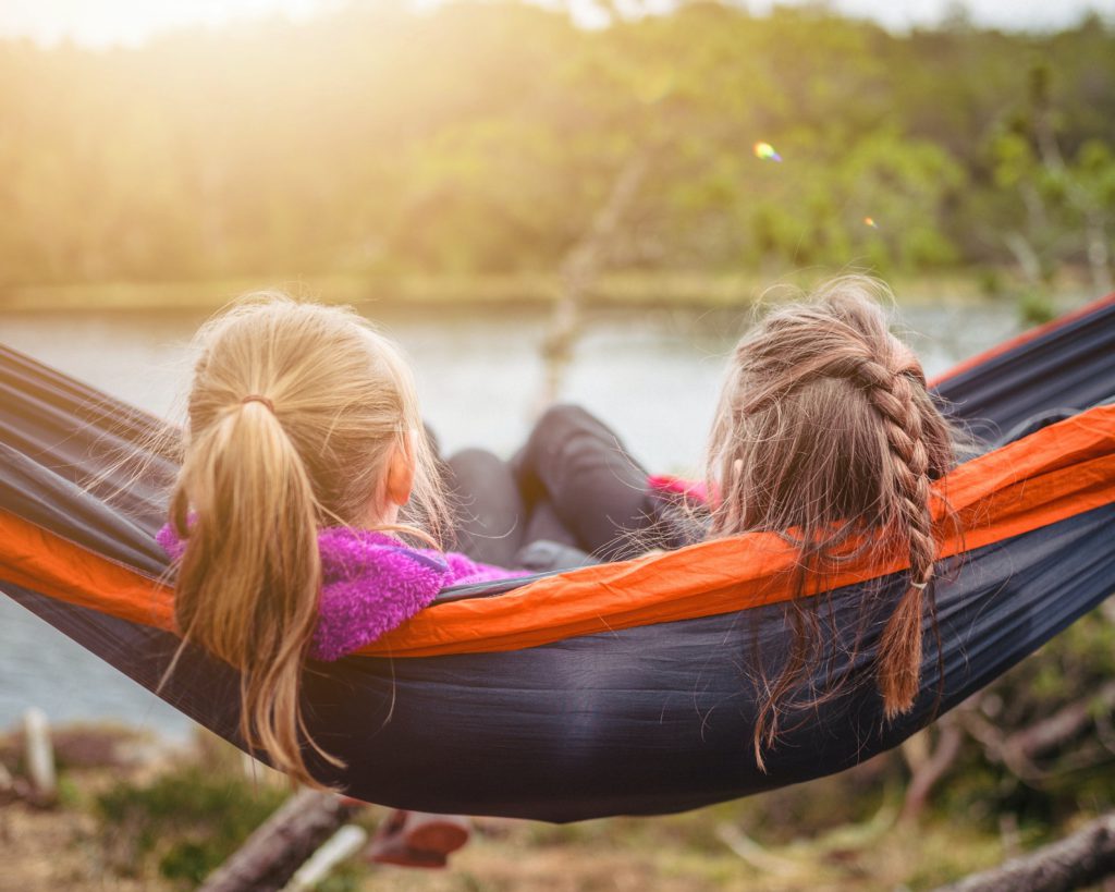 Two girls in a hammock by a lake remind us to pray a short prayer for friends.