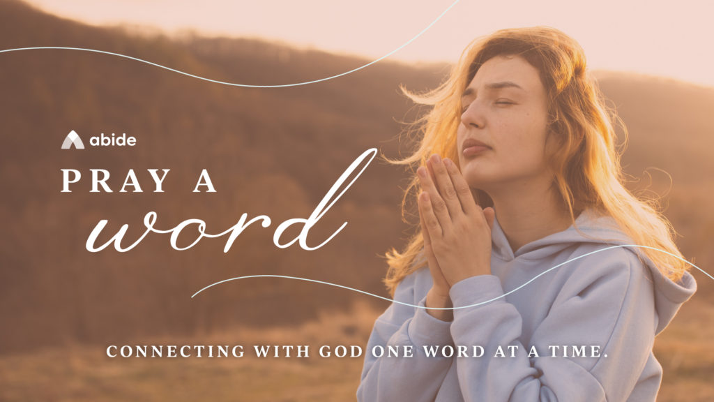 A young woman practices how to pray a word as she stands on a golden hillside.