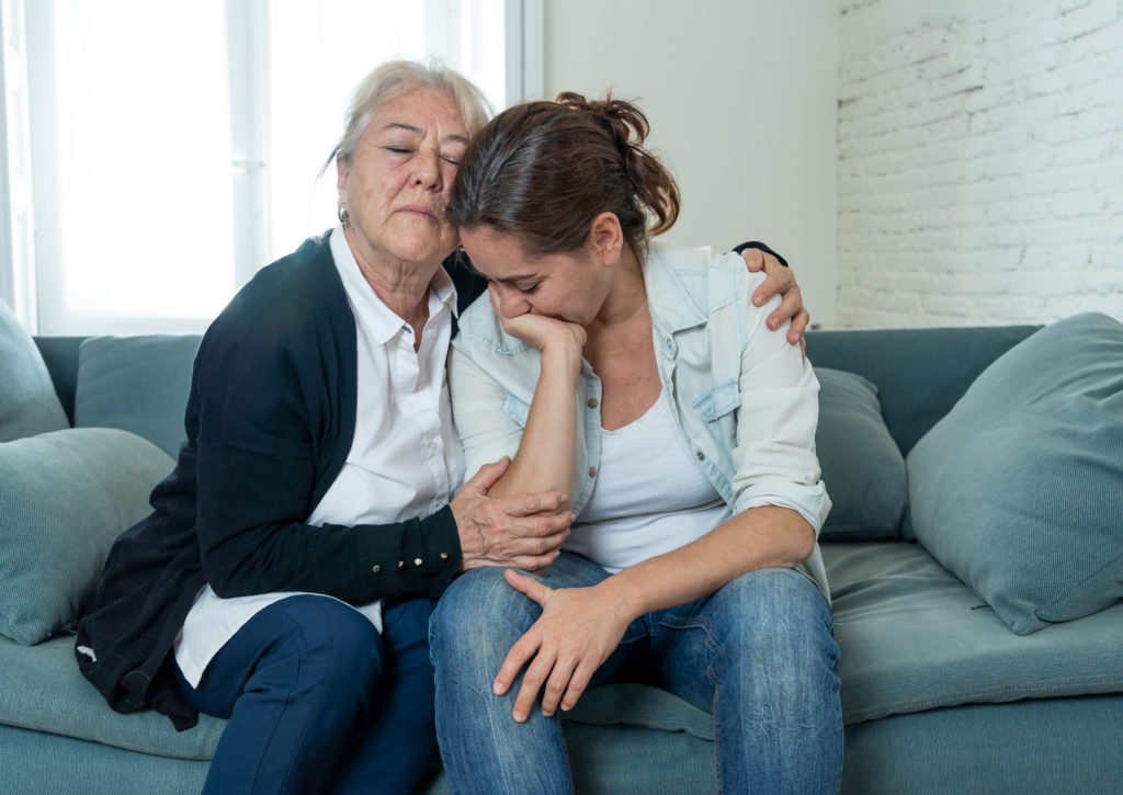 An older mother comforts her young adult daughter as they pray a short prayer for your struggling child.