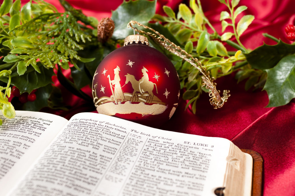 An open Bible in front of a Christmas ornament with the three wisemen offers a Christmas prayer.