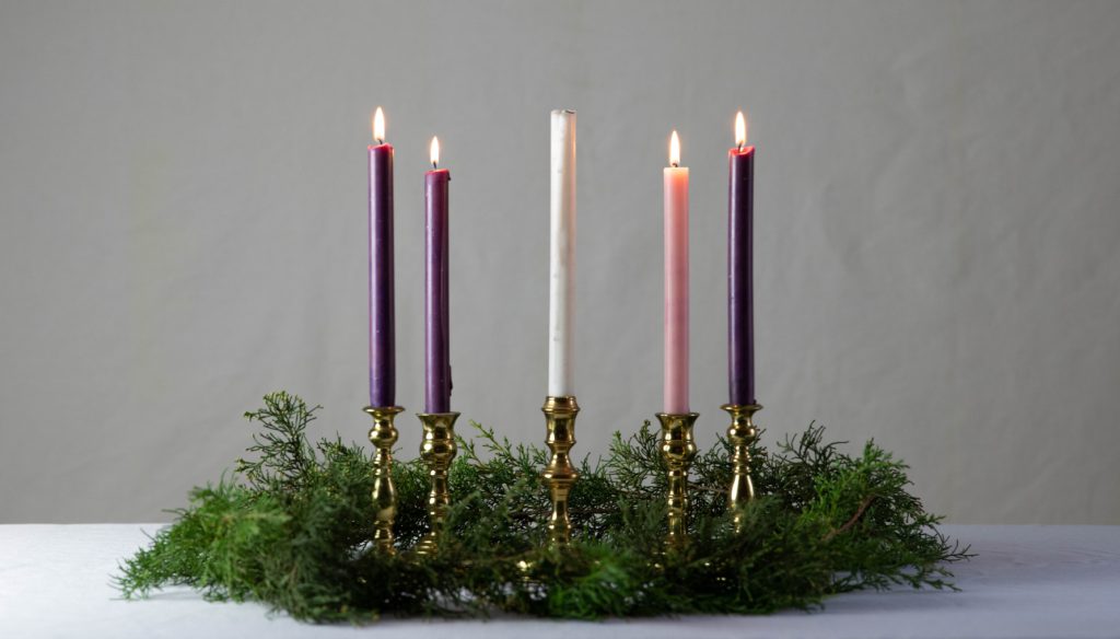 An advent wreath has 4 lit candles reminding us to pray a prayer for the 4th week of advent.