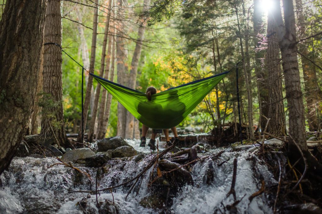 Hanging out with a good friend in a green hammock int he woods can help you find rest emotionally.