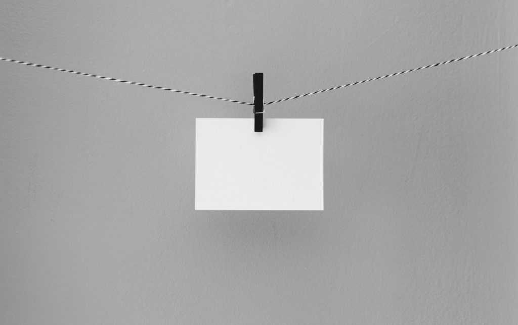 A blank piece of white paper hangs on a line with a clothespin opening up a world for creativity.