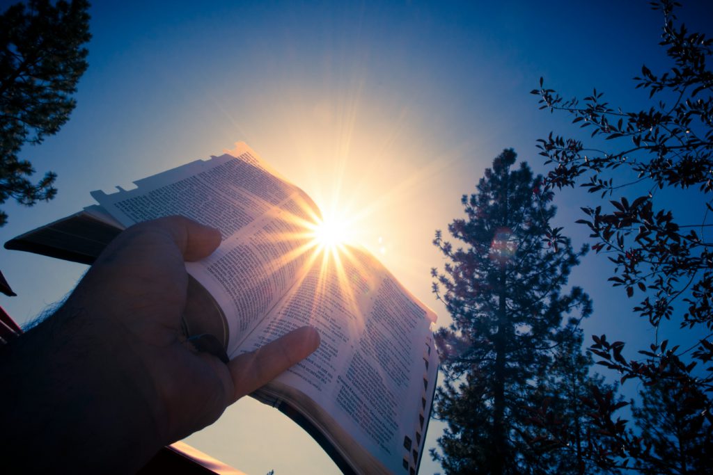 The sun shining on the pages of a Bible illuminate how to live like Jesus.