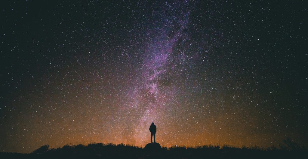 A man stands in silhouette against a the night sky filled with stars as he gazes on God's faithfulness along with the stars.