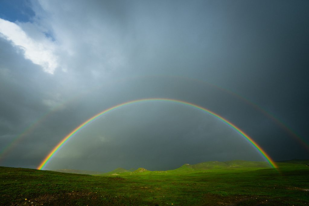 A full rainbow in a storm brings peace.