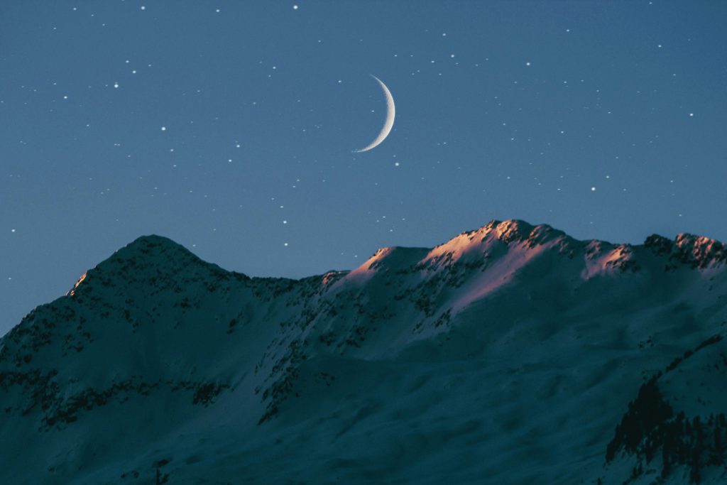 A crescent moon over the mountains on a clear night displays the majesty of God when you struggle with sleeplessness