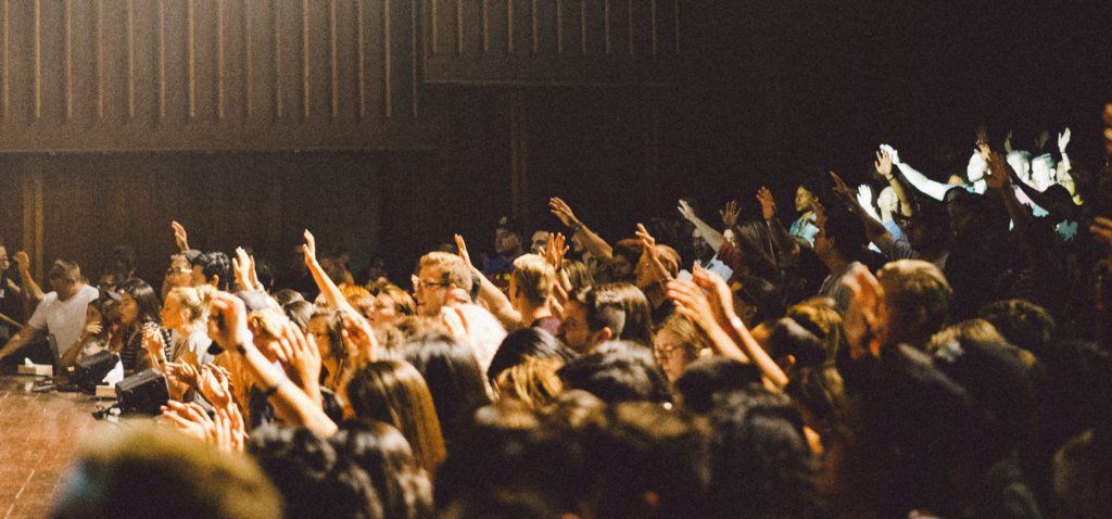 Hands raised with questions in a classroom remind us to confront challenges to faith with confidence.