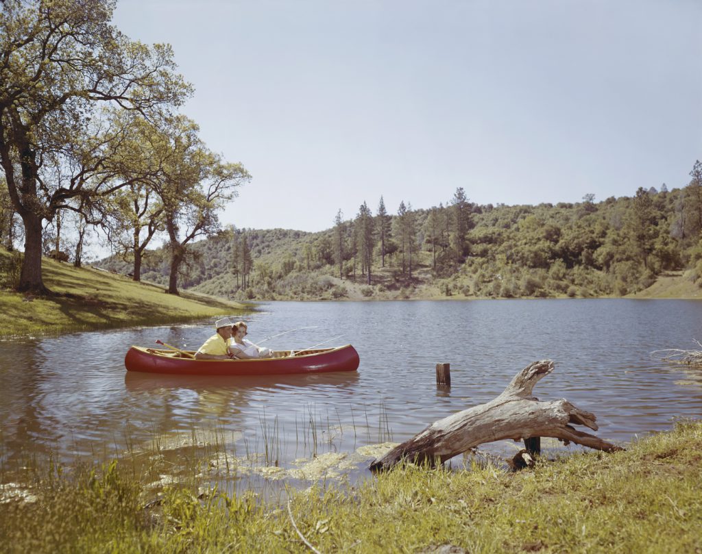 A couple in a red canoe on a lake in the mountains nurture biblical patience.