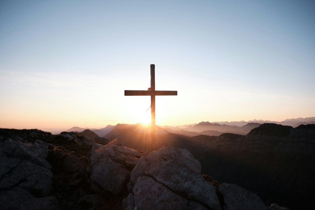 A cross on a hill at sunset speaks to the power of the Almighty.