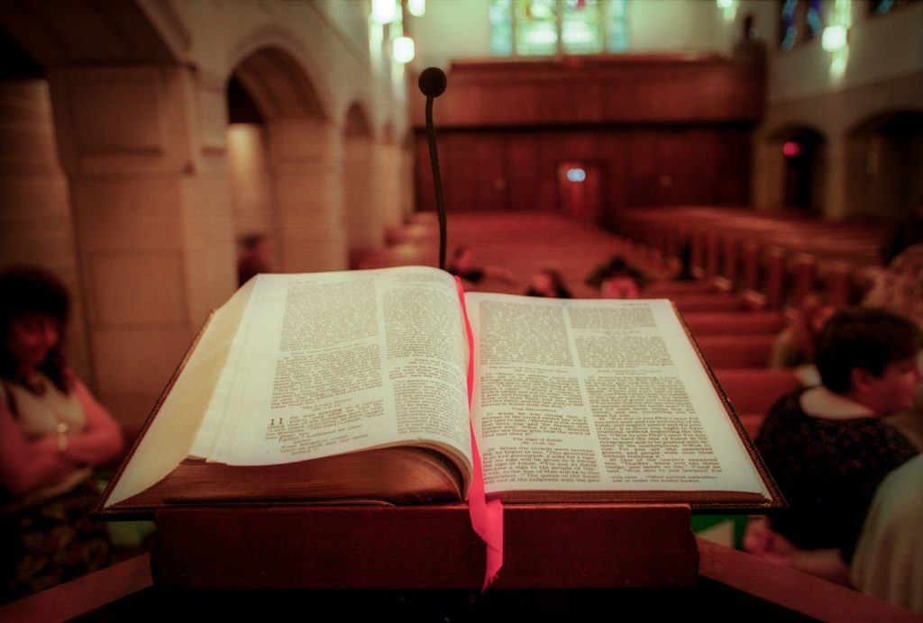 An open Bible at the front of a church leads the way to spiritual awakening.