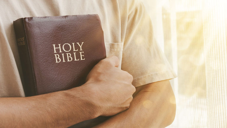 Man hugging the Bible to show he knows how to hold on to hope