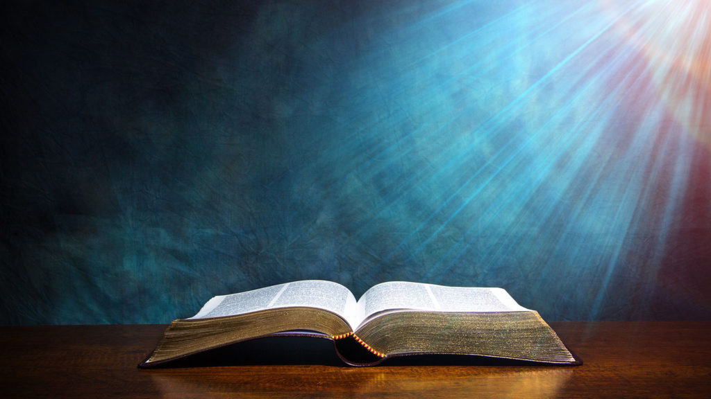 Royalty-free stock photo: A heavenly beam of light illuminates an open Bible