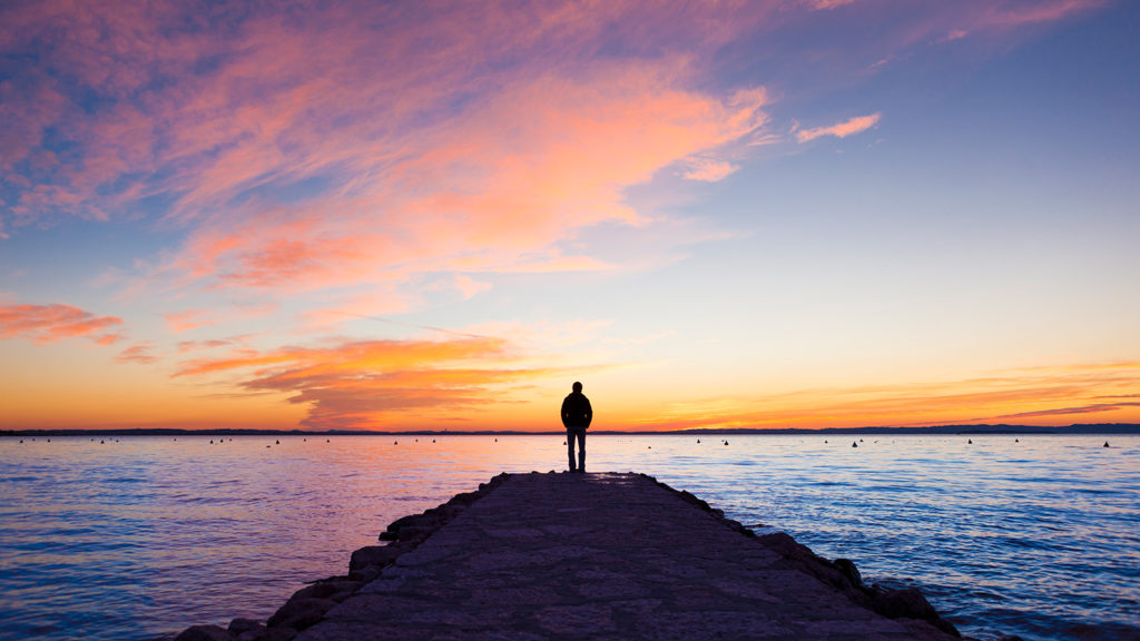Royalty-Free Stock Photo: Man watching the sunset and thinking about divine reflections.