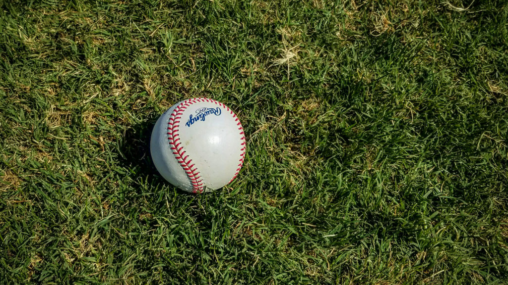 A baseball sits on a grassy field encouraging you to keep your eye on the ball in your faith.
