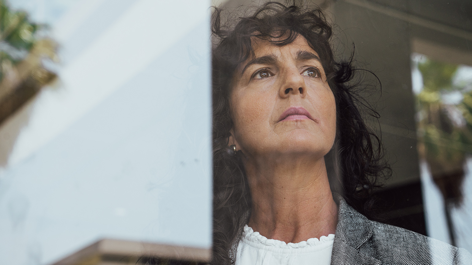 Royalty-Free Stock Photo: Woman looking out a window and turning doubt into strength.