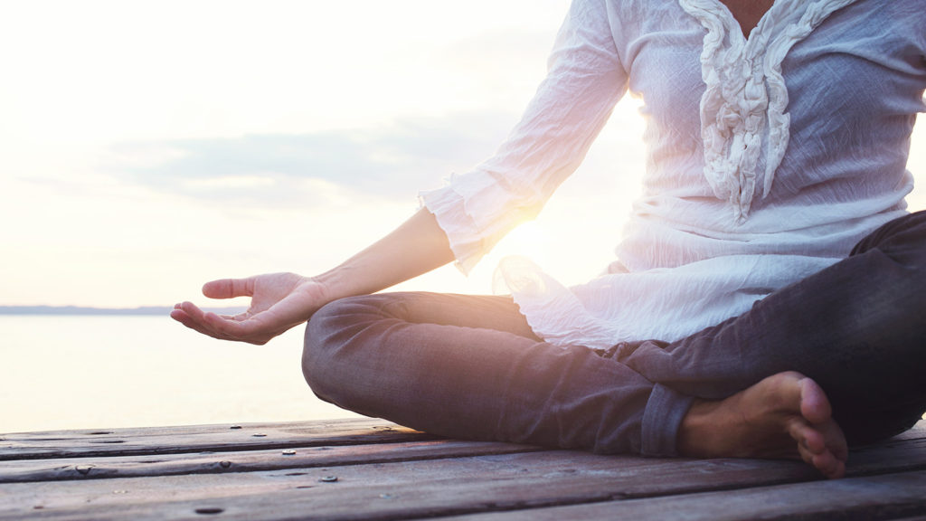Royalty-Free Stock Photo: Woman meditating outdoors to find harmony.