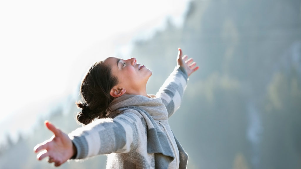 Royalty-Free Stock Photo: Woman with arms outstretched, finding harmony outdoors.