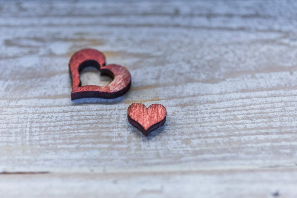 Two red wooden hearts, one taken from the middle of the other, reminds you to see yourself as God sees you.