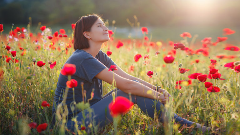 Royalty-Free Stock Photo: Woman in a poppy field trying to seek confidence in God's image.