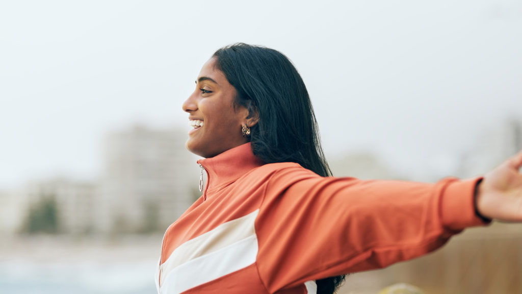 Royalty-Free Stock Photo: Young, smiling woman with open arms.