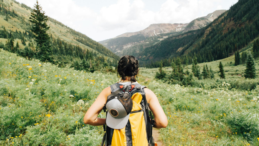 A woman with a backpack sets out on a hike through the mountains to explore her true worth.