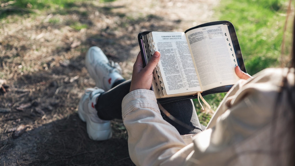 Royalty-Free Stock Photo: Woman reading Bible to uncover God's vision for herself.