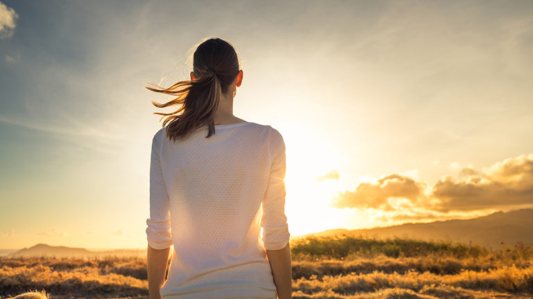 Royalty-Free Stock Photo: Woman watching the sunset and embracing unexpected insights.