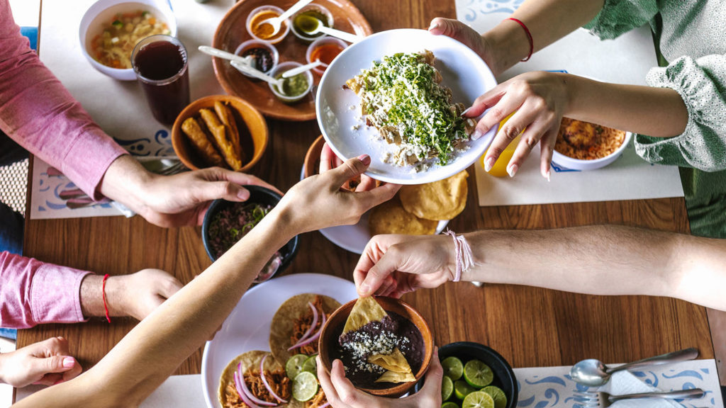 A group of friends share a Mexican-food meal as they enjoy Christian fellowship.