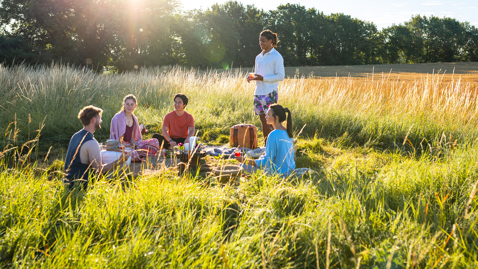 Friends enjoy Christian fellowship over a picnic outside in a field