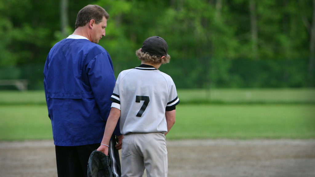 A baseball coach mentors a young player like in a classic baseball movie.
