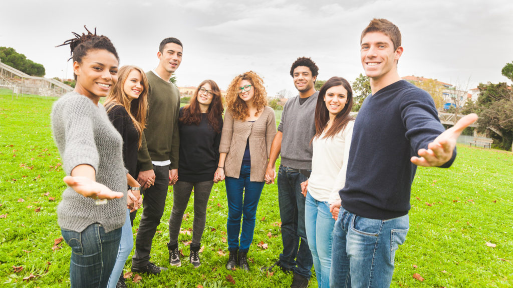 Royalty-free stock image: Brothers and wisters in Christ welcome a newcomer with smiles; Getty Images