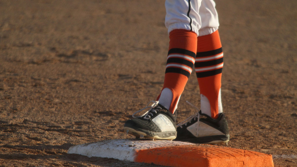 Image of a baseball player's feet standing on first base after being walked by the pitcher as a metaphor for spiritual growth.