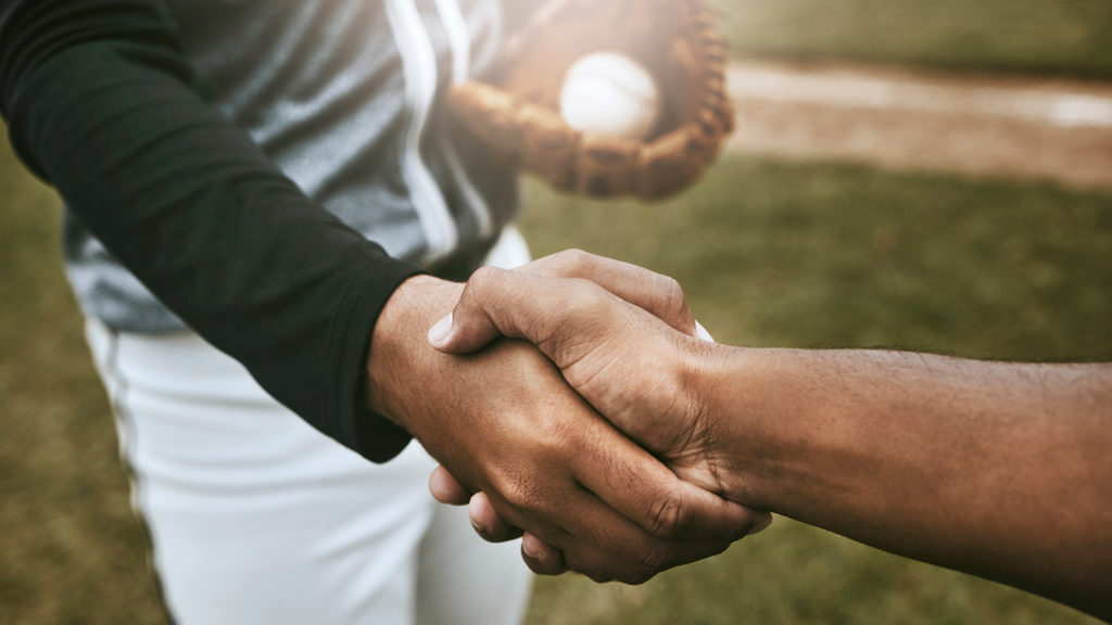 Royalty-Free Stock Photo: Two baseball players shaking hands and sharing an understanding of faith.