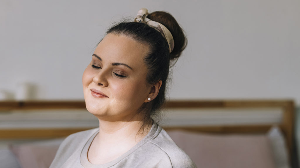 A woman closes her eyes to say her bedtime prayers so she can sleep better