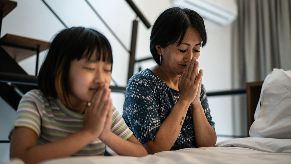 Daughter and mother saying their bedtime prayers together