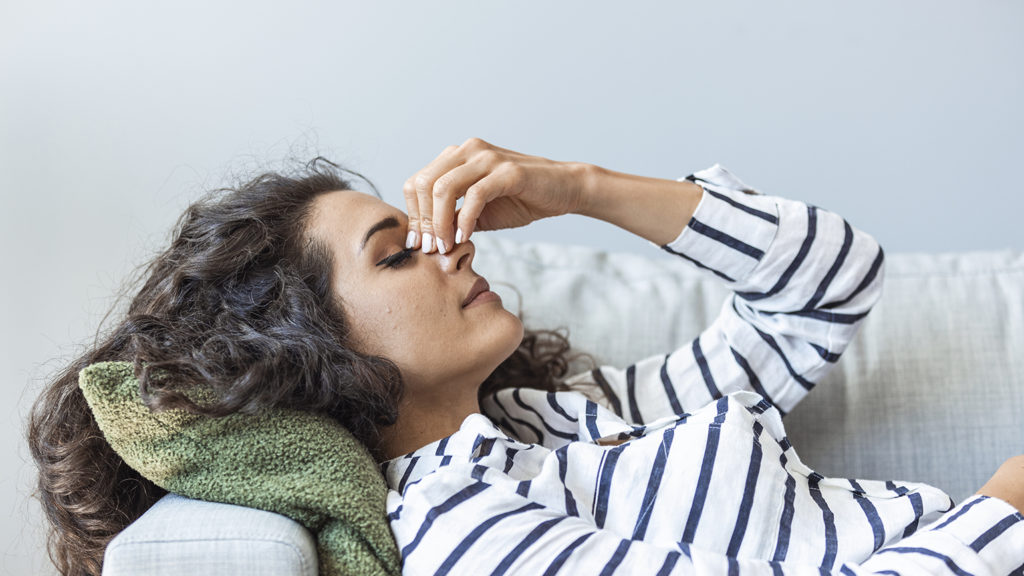 Woman lying on her couch having difficulty turning off her mind