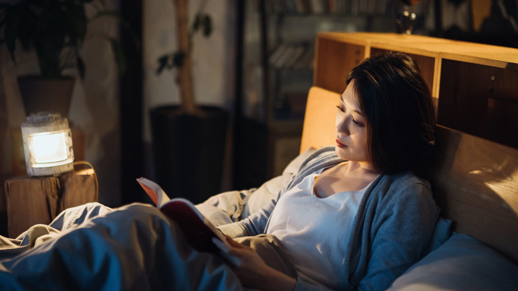Woman reading her Bible in bed when she can't sleep
