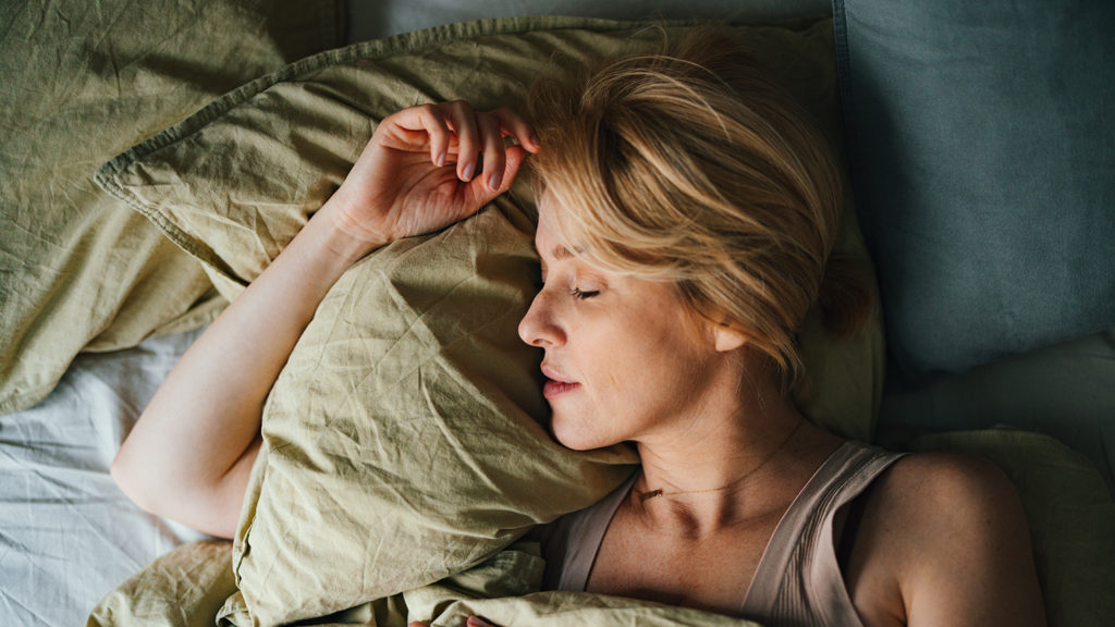 Woman sleeping in bed after getting help with insomnia