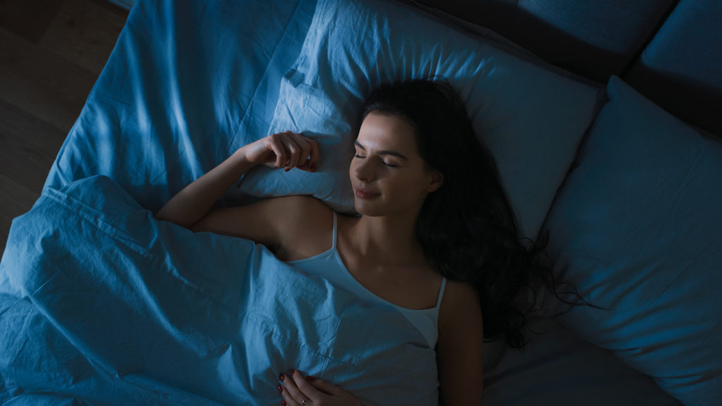 Woman sleeping in her bed after learning to turn her mind off