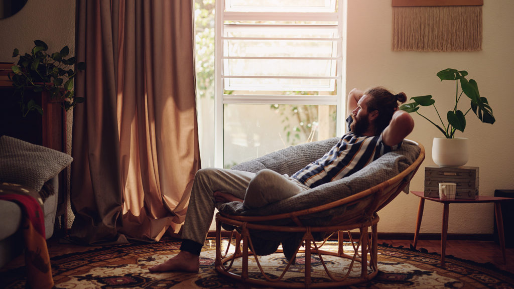 Royalty-Free Stock Photo: Young man preparing for a good night's sleep by relaxing on a chair at home.