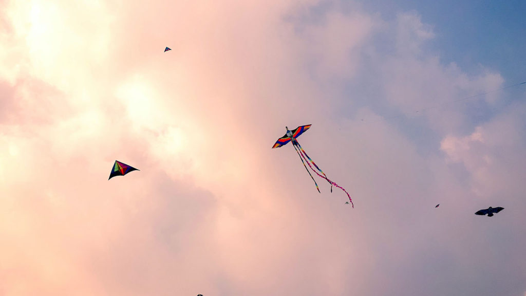 Kites fly in a sky with sunset-colored clouds as they show you how to love your enemies by releasing bitterness.